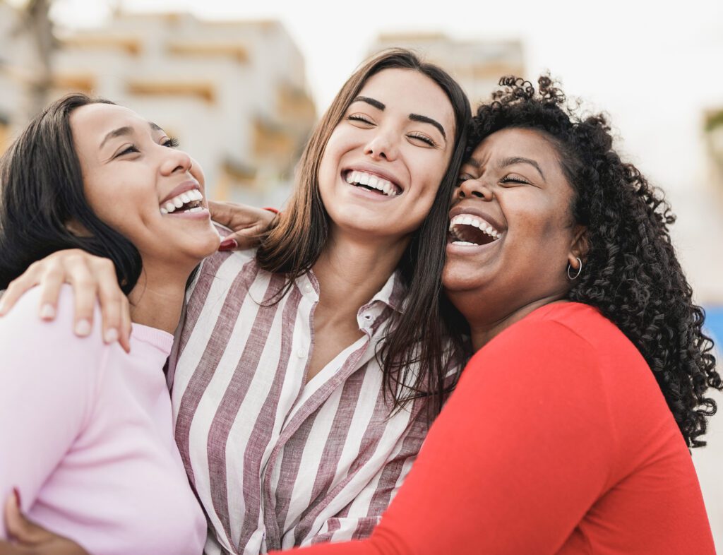 A group of young women sharing a happy moment outdoors.