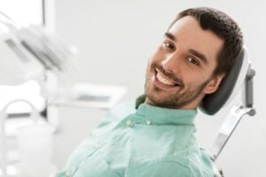 A young man in an exam room smiling confidently.