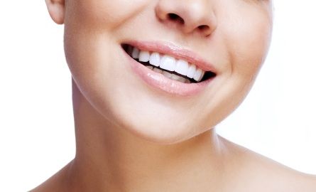 A woman smiling with straight teeth from Invisalign in Plano.